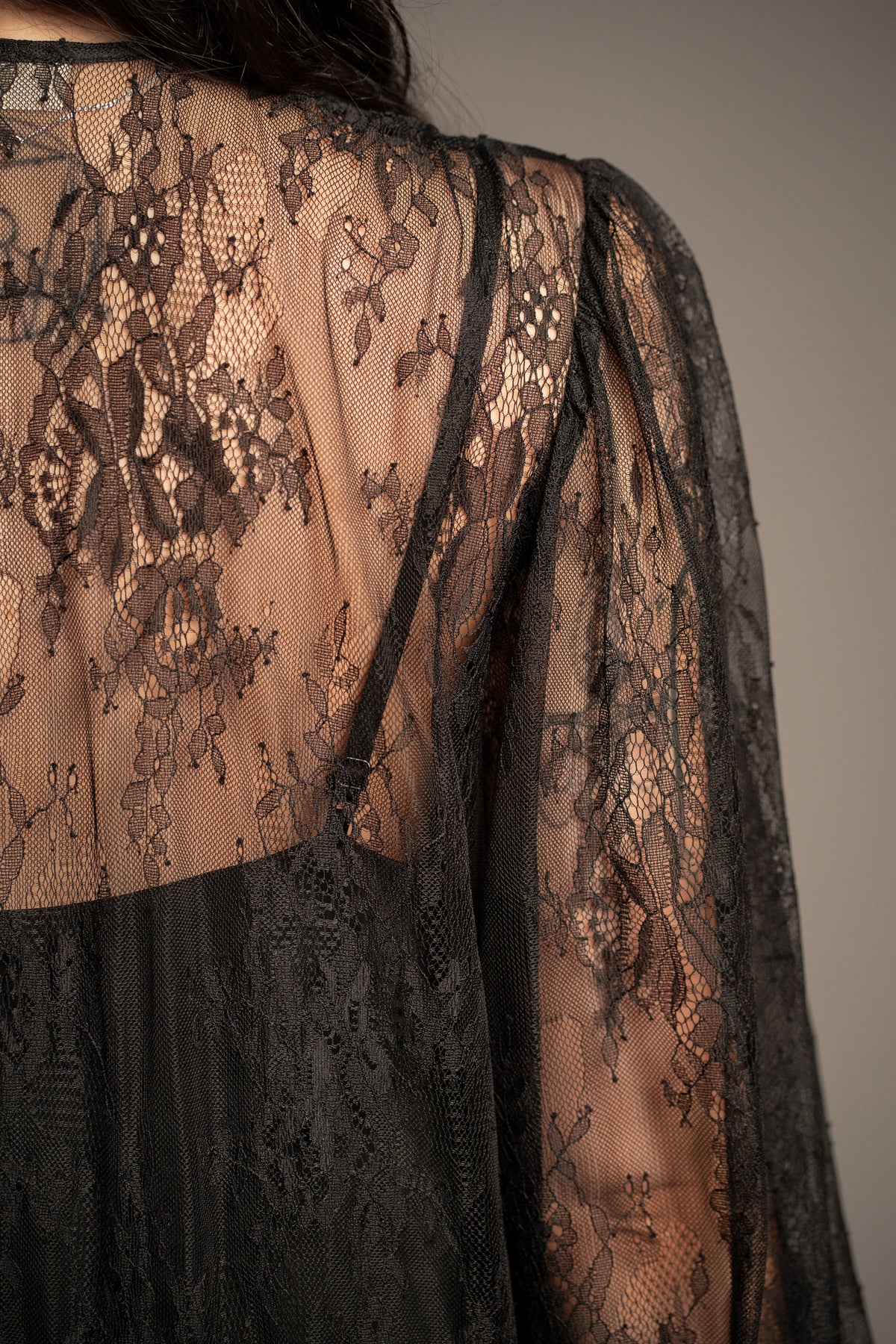 Close-up of Rhiannon black lace maxi dress showcasing intricate floral lace pattern and sheer fabric detail