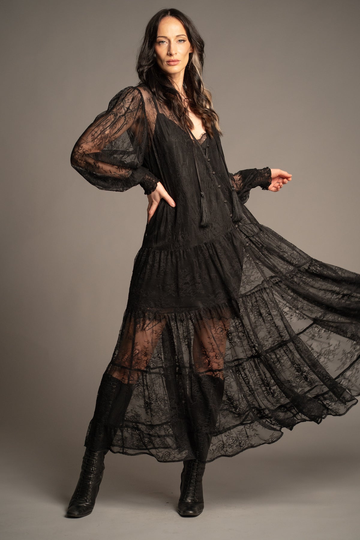 Rhiannon black lace maxi dress with tiered skirt, sheer lace sleeves and tassel tie neckline front view