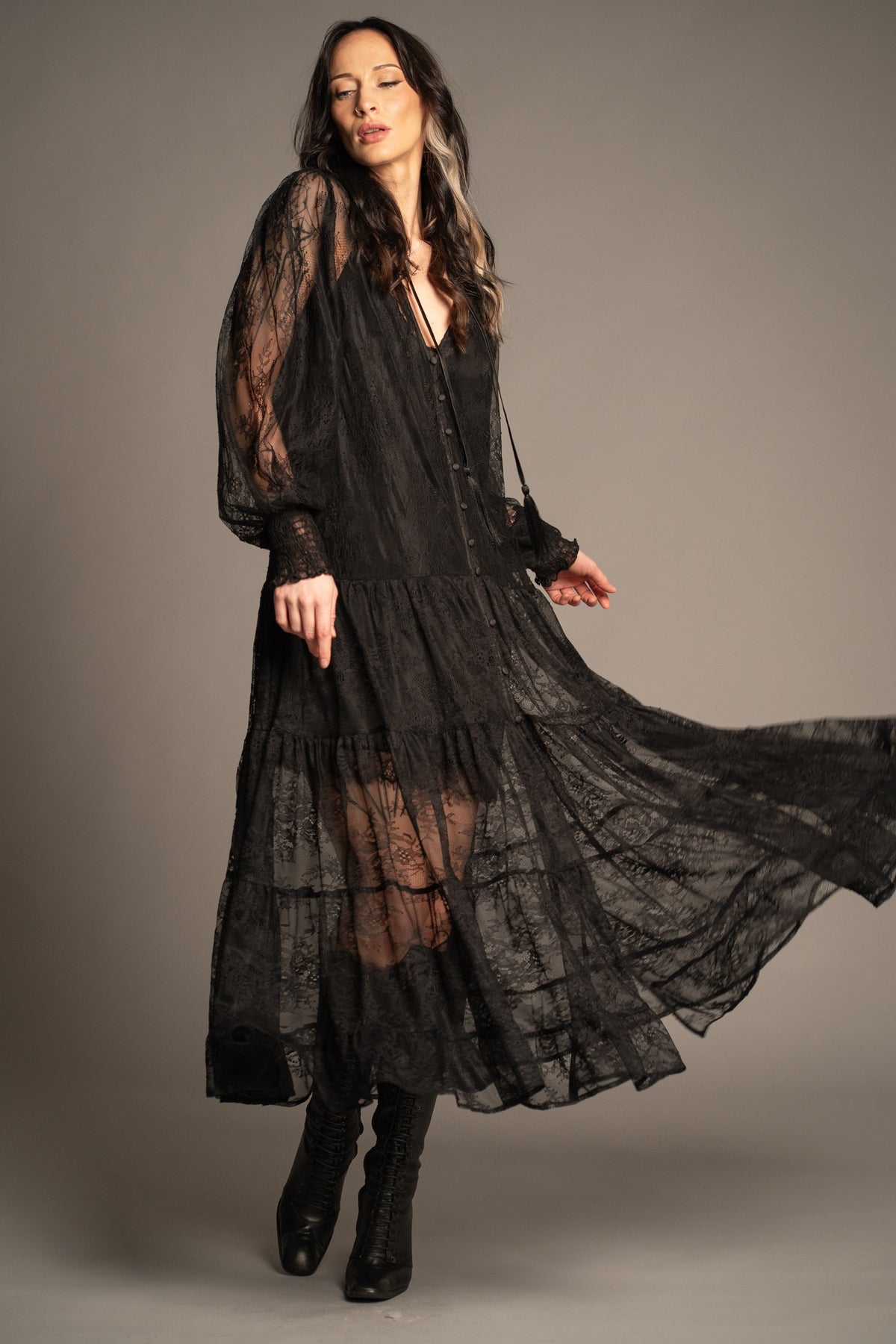 Rhiannon black lace maxi dress with tiered skirt, sheer lace sleeves and tassel tie neckline front view
