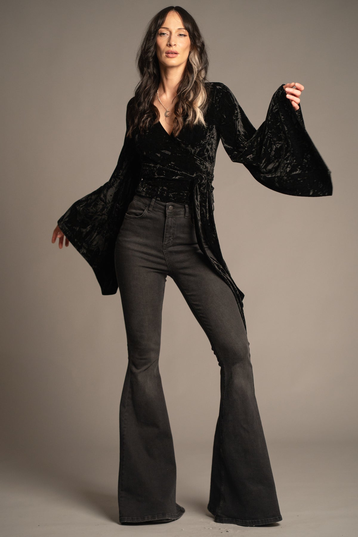 Sally black velvet wrap top detail featuring statement bell sleeve, waist tie and crushed velvet texture