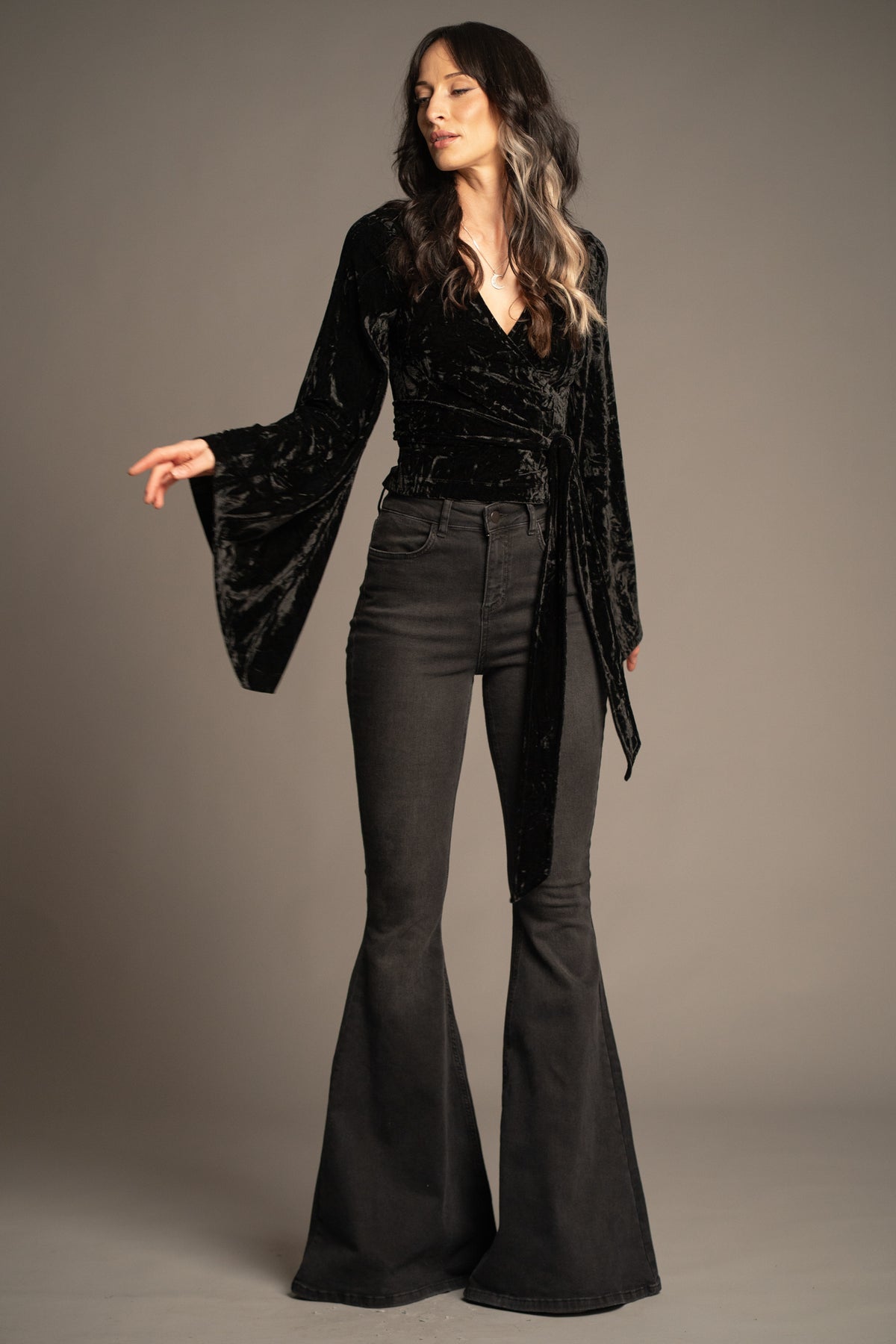 Sally black velvet wrap top with tie waist detail and dramatic bell sleeves front view