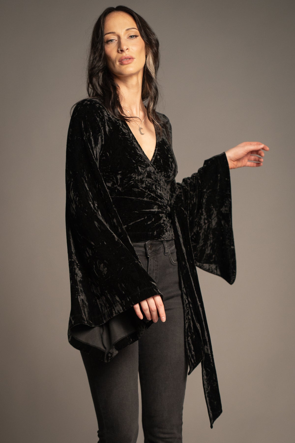 Sally black velvet wrap top detail featuring statement bell sleeve, waist tie and crushed velvet texture