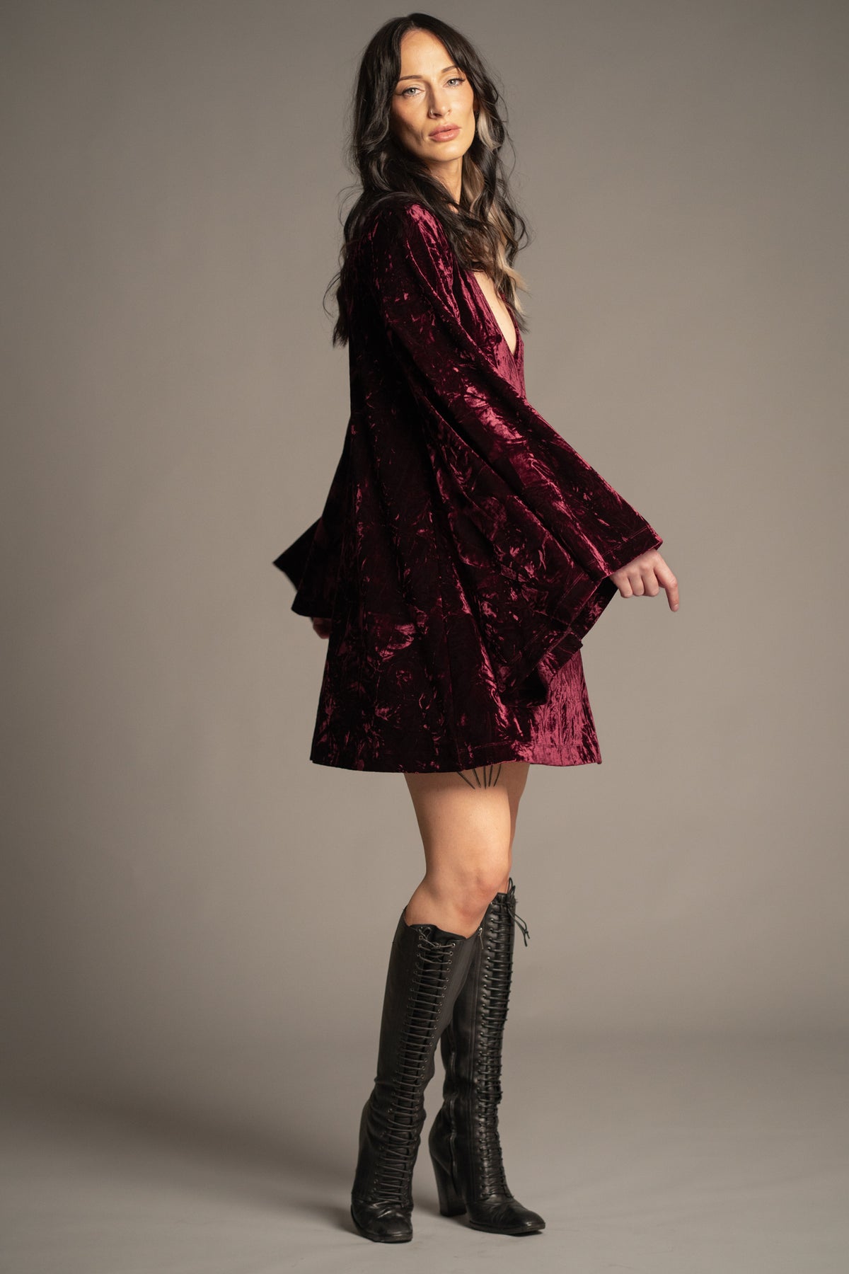Sara merlot velvet mini dress side view with deep V-neck, relaxed fit and dramatic bell sleeves