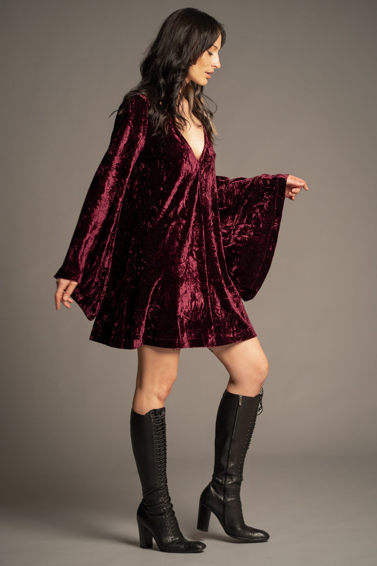 Sara merlot velvet mini dress side view with deep V-neck, relaxed fit and dramatic bell sleeves