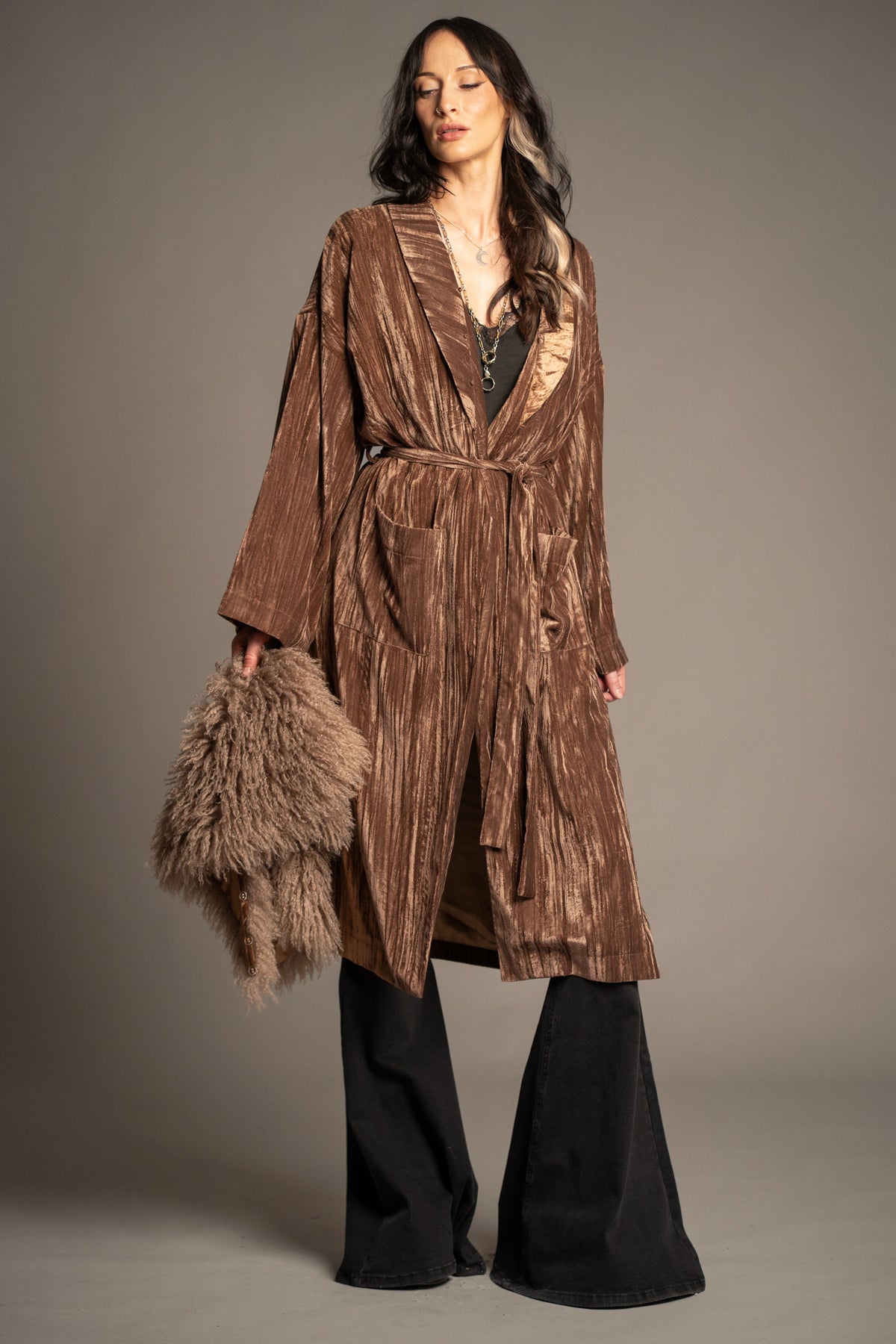 Sienna bronze velvet kimono jacket fastened with a self-tie belt, featuring patch pockets and model holds oversized detachable faux fur collar