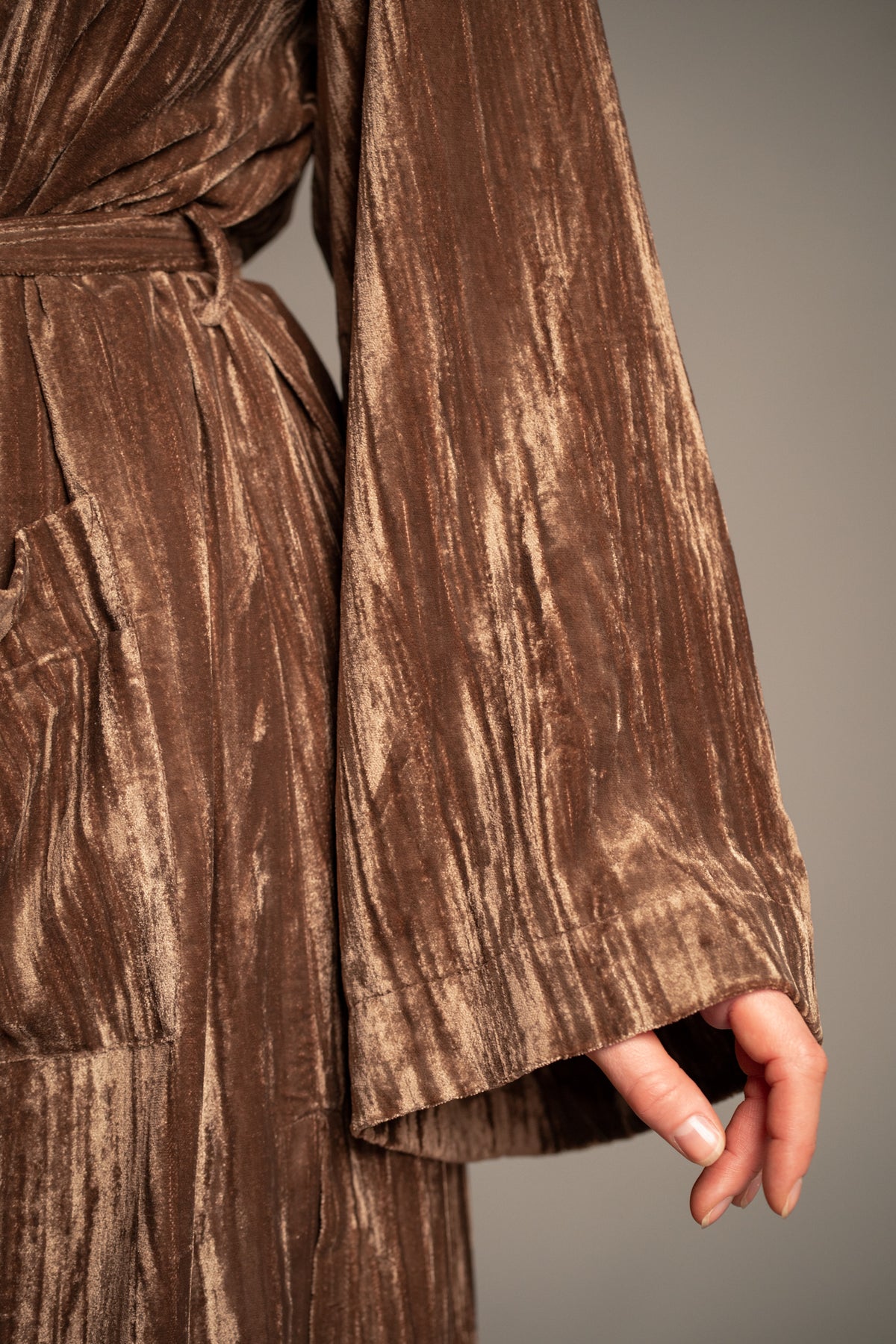 Close-up of Sienna velvet kimono jacket sleeve showcasing lustrous bronze crushed velvet fabric and wide kimono-style cuff