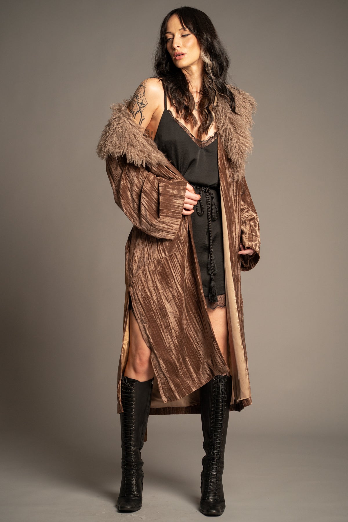 Sienna velvet kimono jacket styled over a belted black lace-trim mini dress with knee-high boots, featuring a dramatic faux fur collar