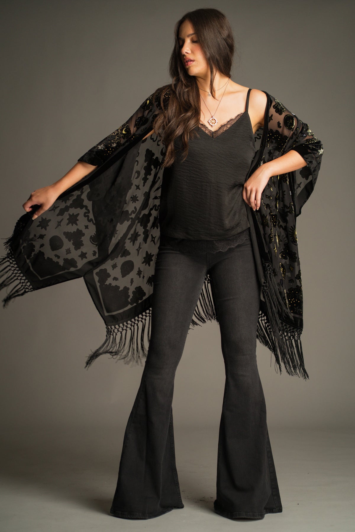 Suzi Skull Black Devore Kimono by Little Lies styled with a black camisole and Hendrix Denim Flares, featuring velvet burnout skull motifs and bohemian-inspired fringe detailing