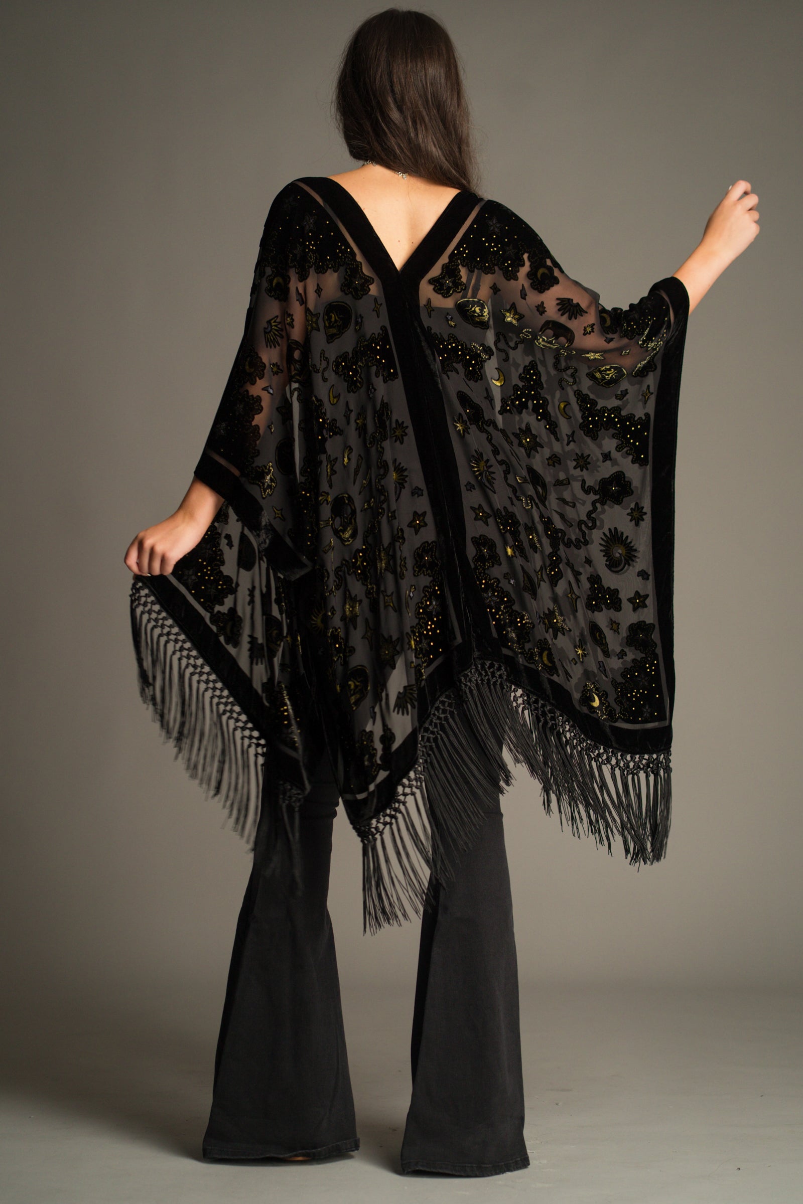 Back view of the Suzi Skull Black Devore Kimono showcasing the sheer devore fabric, velvet skull detailing, celestial motifs and dramatic fringe hem