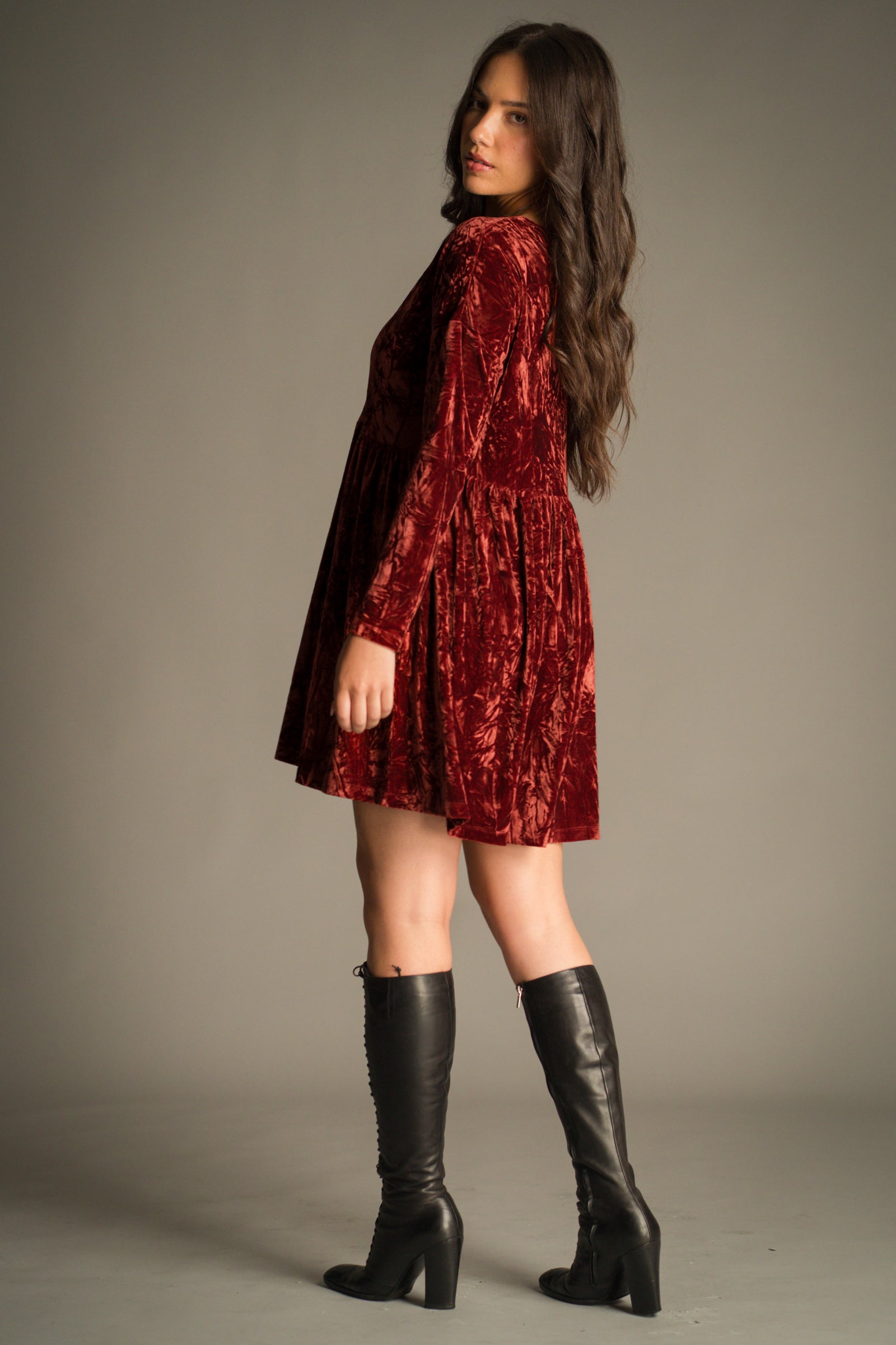 Full length side view of the Velvet Goldmine Rust Smock Dress in copper-rust velvet showing the mini length and full sleeve length.