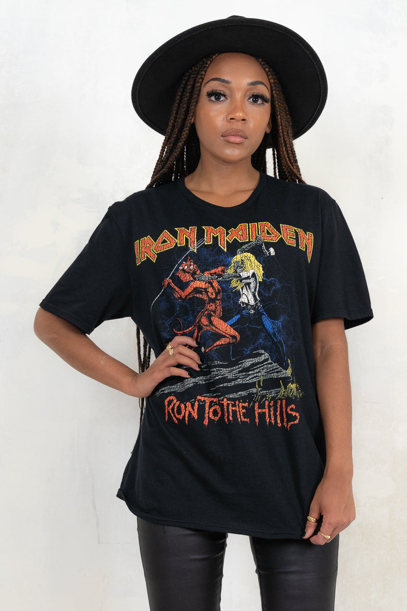 Model wearing Iron Maiden Run to the Hills Tee- Black Iron Maiden band tee with red and yellow band logo