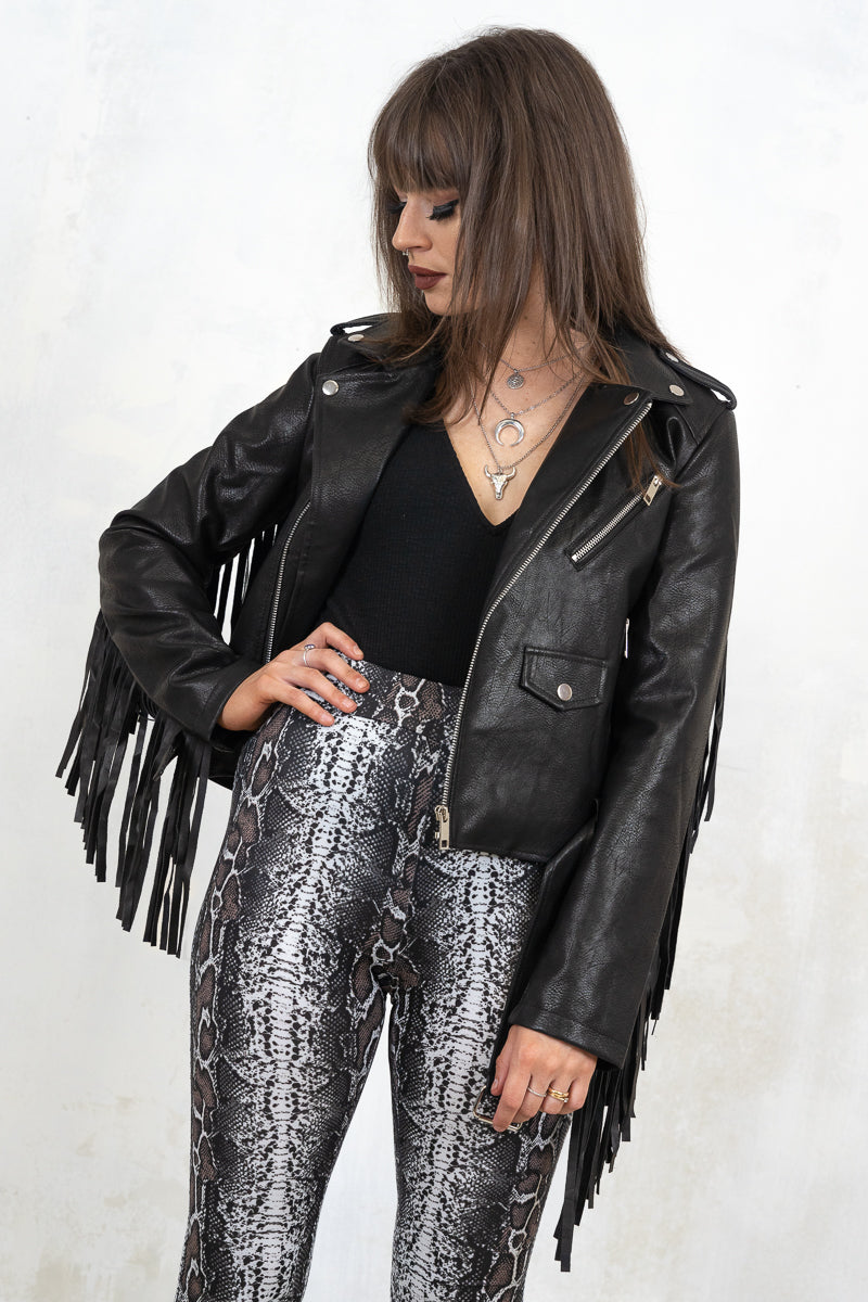 Model wearing Thunderstruck Fringed Biker Jacket, a black biker jacket with Zip fastening with side zip pockets and belted hem, back fringe detail