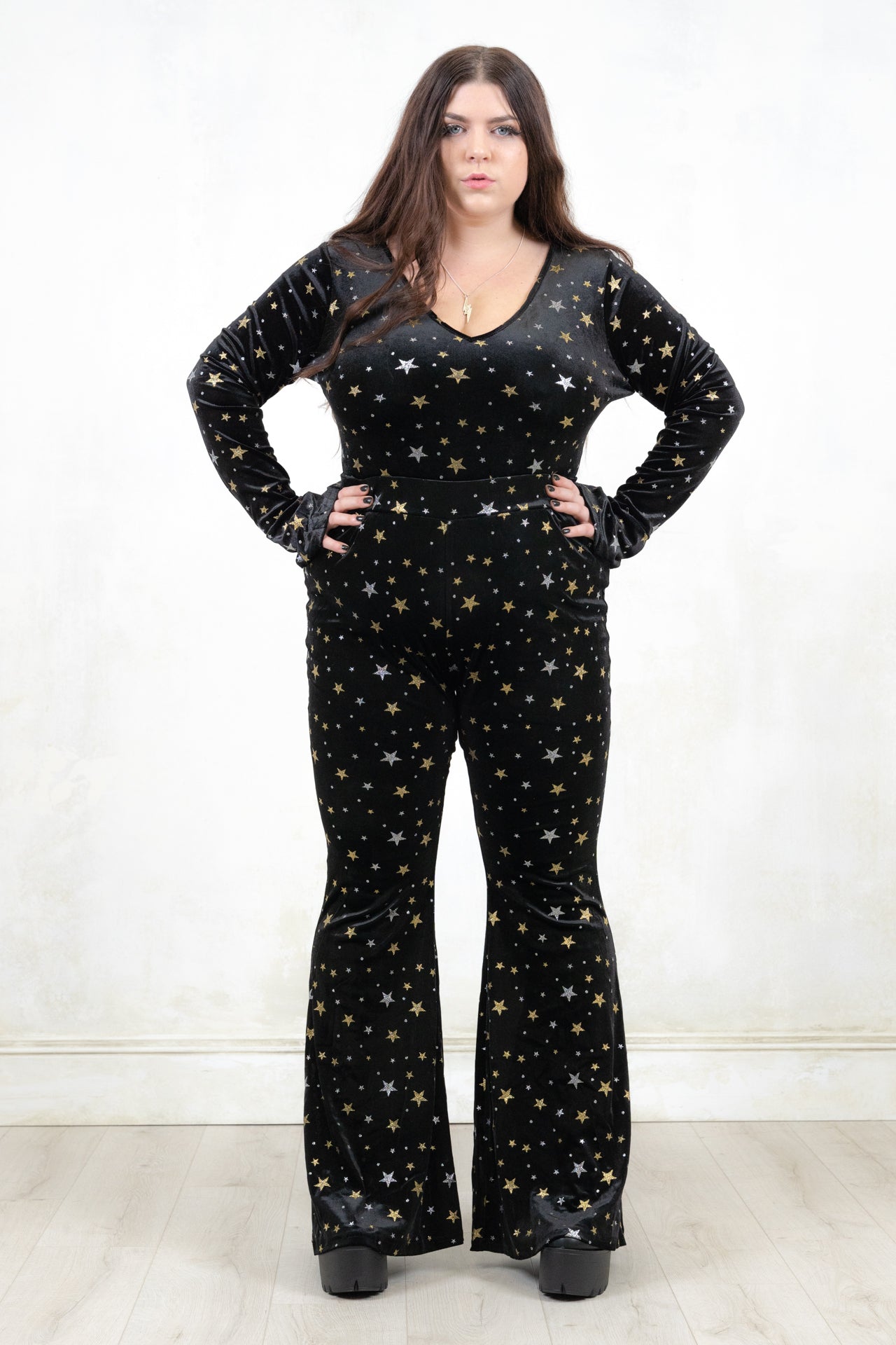 Model wearing Space Oddity Glitter Velvet Bodysuit, a Black Velvet with Silver and Gold Glitter Bodysuit, with Front button popper fastening with plunge neck and flared cuff
