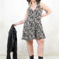 Model wearing World Turning Trapeze Dress - black paisley print trapeze shape dress with with no button zip closure
