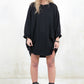 Model wearing black,  slouchy, relaxed fit sweatshirt dress with long sleeves