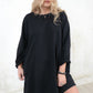 Model wearing black, slouchy, relaxed fit sweatshirt dress with long sleeves