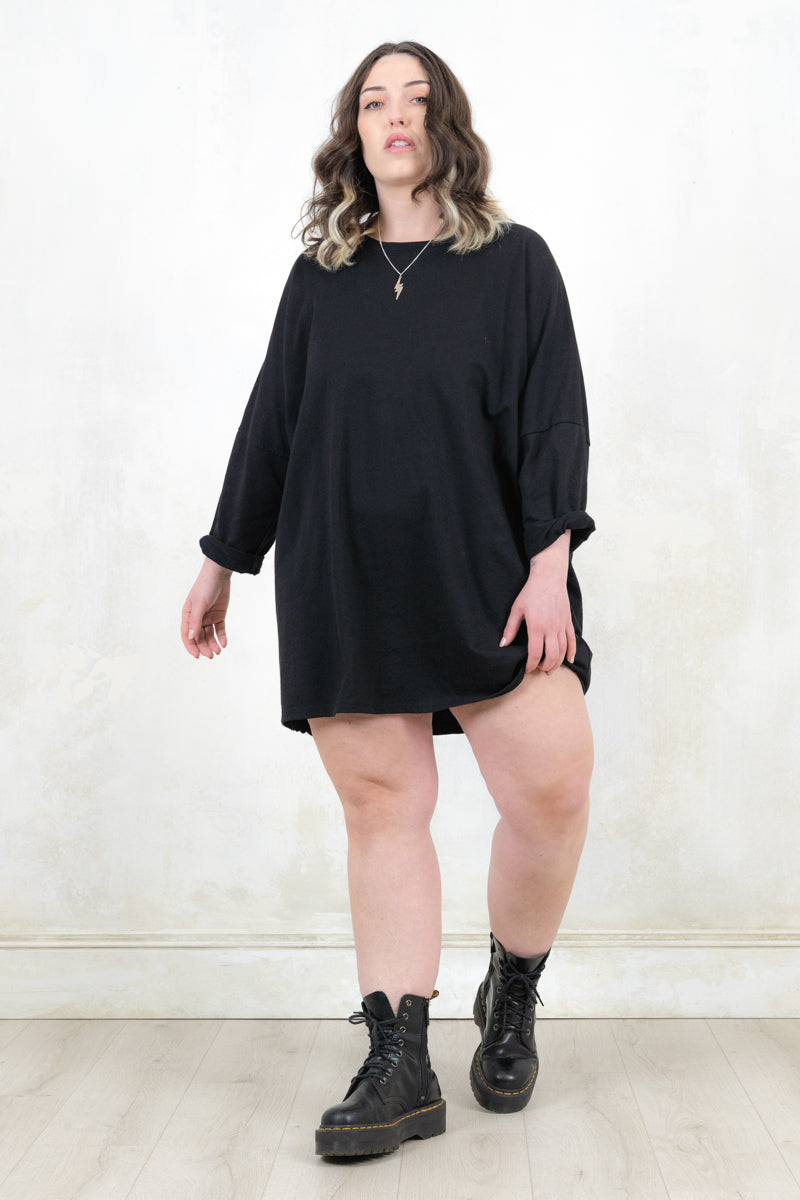 Model wearing black, slouchy, relaxed fit sweatshirt dress with long sleeves
