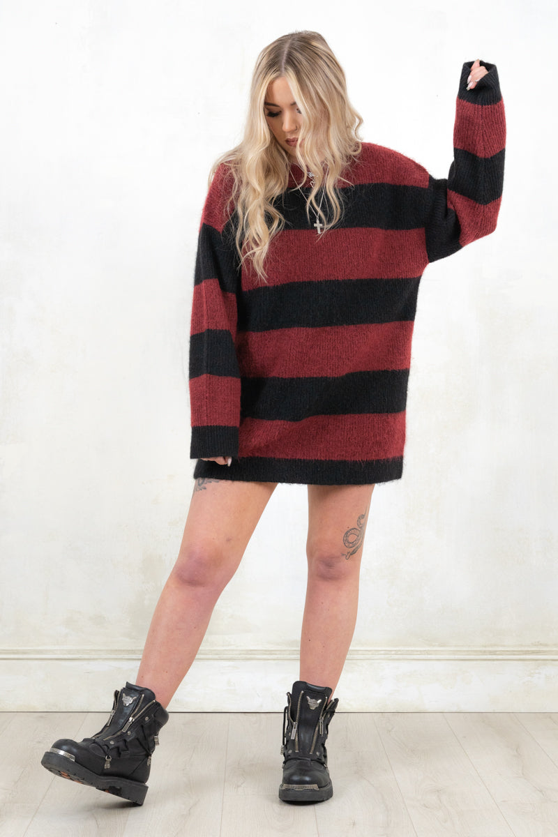 Model wearing Kurt Striped Knit, relaxed fit black and oxblood strip knit jumper