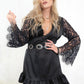 Model wearing Edge of Seventeen Mini Dress, a luxe black satin dress with a sheer lace back and eyelash lace flared sleeves
