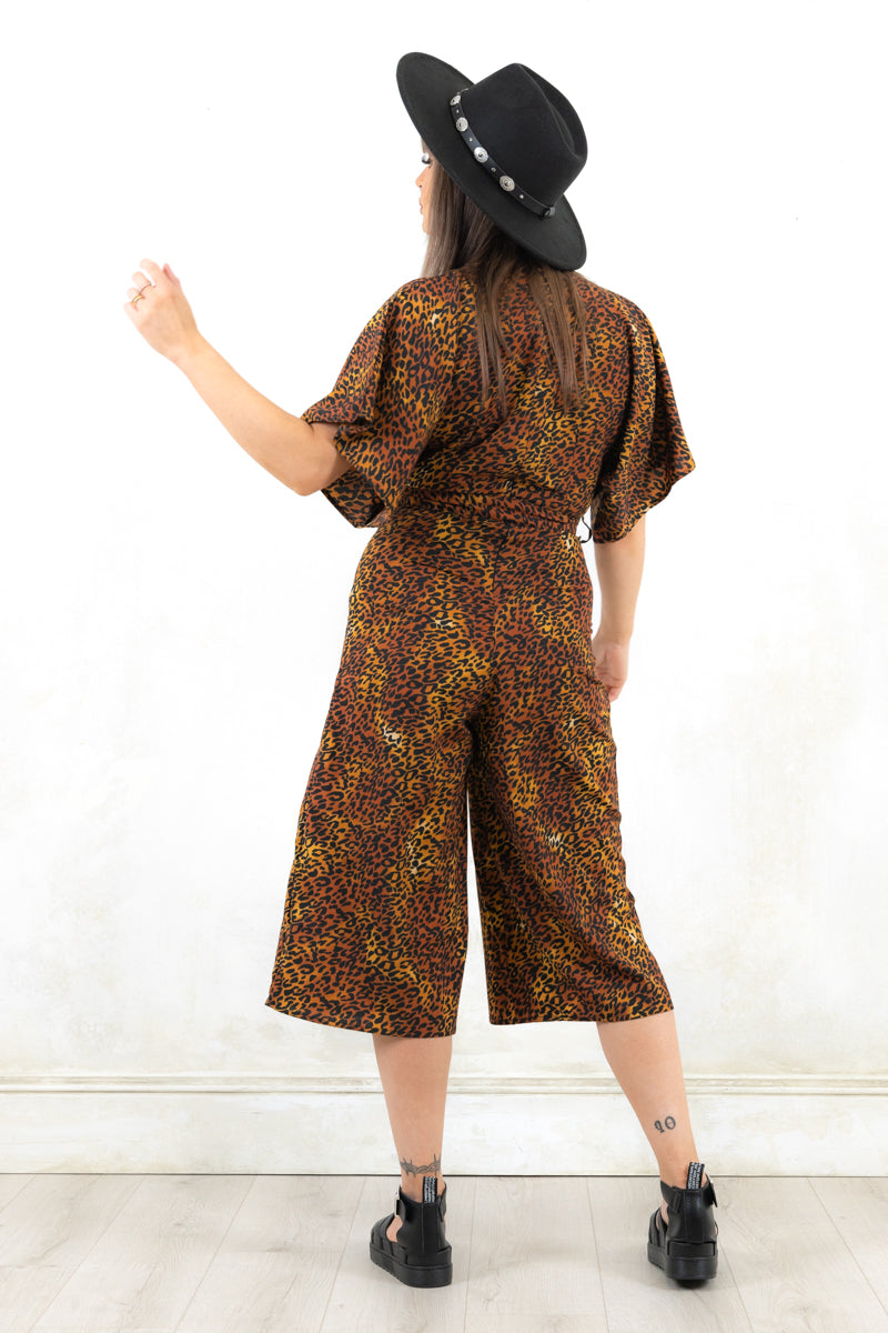 Model wearing Rebel Rock Me Leopard Jumpsuit - leopard print faux wrap jumpsuit with kimono sleeves and wide culotte legs