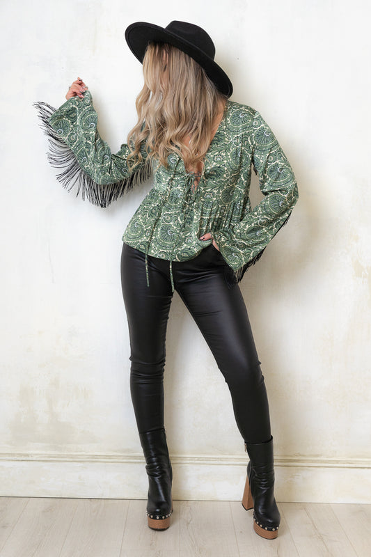 Model wearing Secret Garden Fringed Top - a Sage Green Paisley Print, No button or zip closure top with double tie front, peplum hem, flared sleeves and back fringing detail