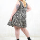 Model wearing World Turning Trapeze Dress - black paisley print trapeze shape dress with with no button zip closure