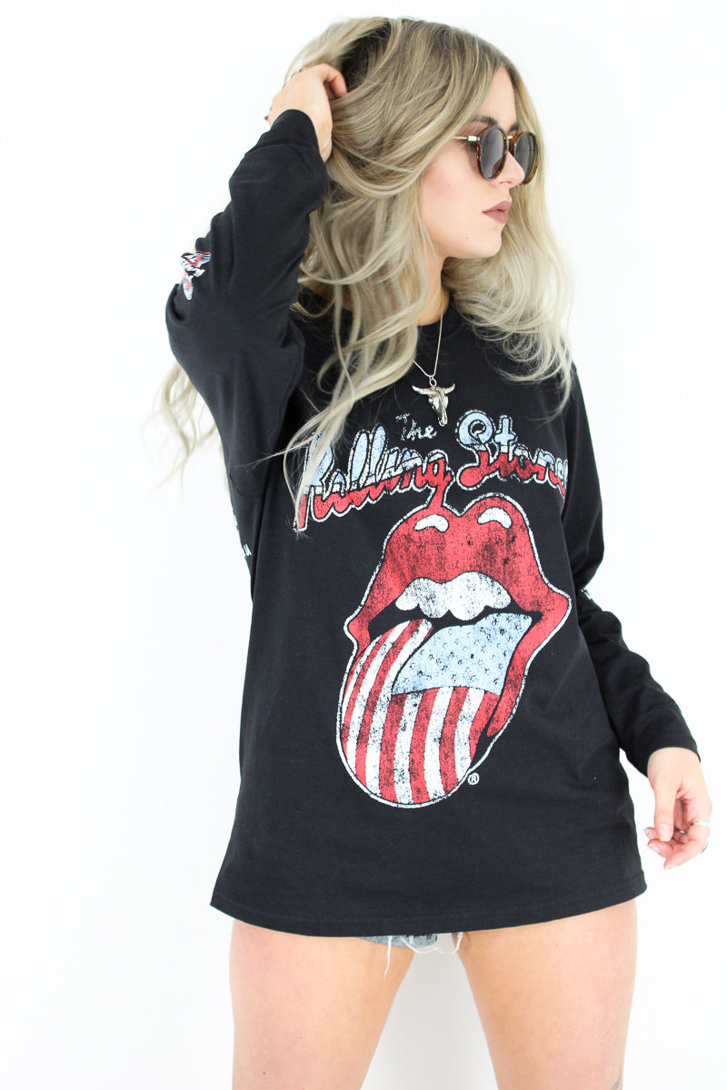 Model wearing The Rolling Stones '78 Long Sleeve Tee - Black Long Sleeve Rolling Stones Tee with American Flag Print Tongue Design on front and Tour Dates on back